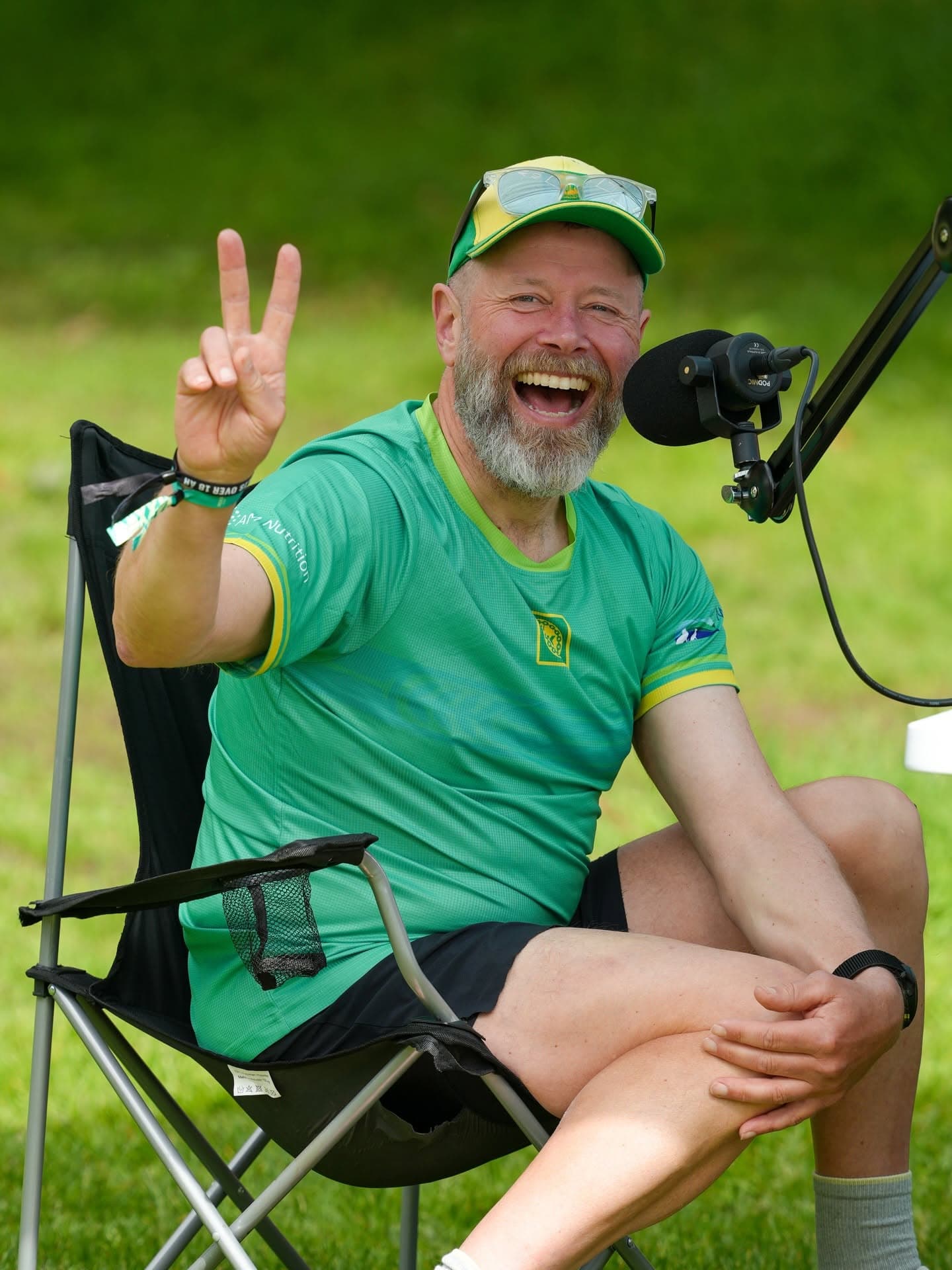 En fra Lavterskel-gjengen smiler ved mikrofonen og viser fredstegn
