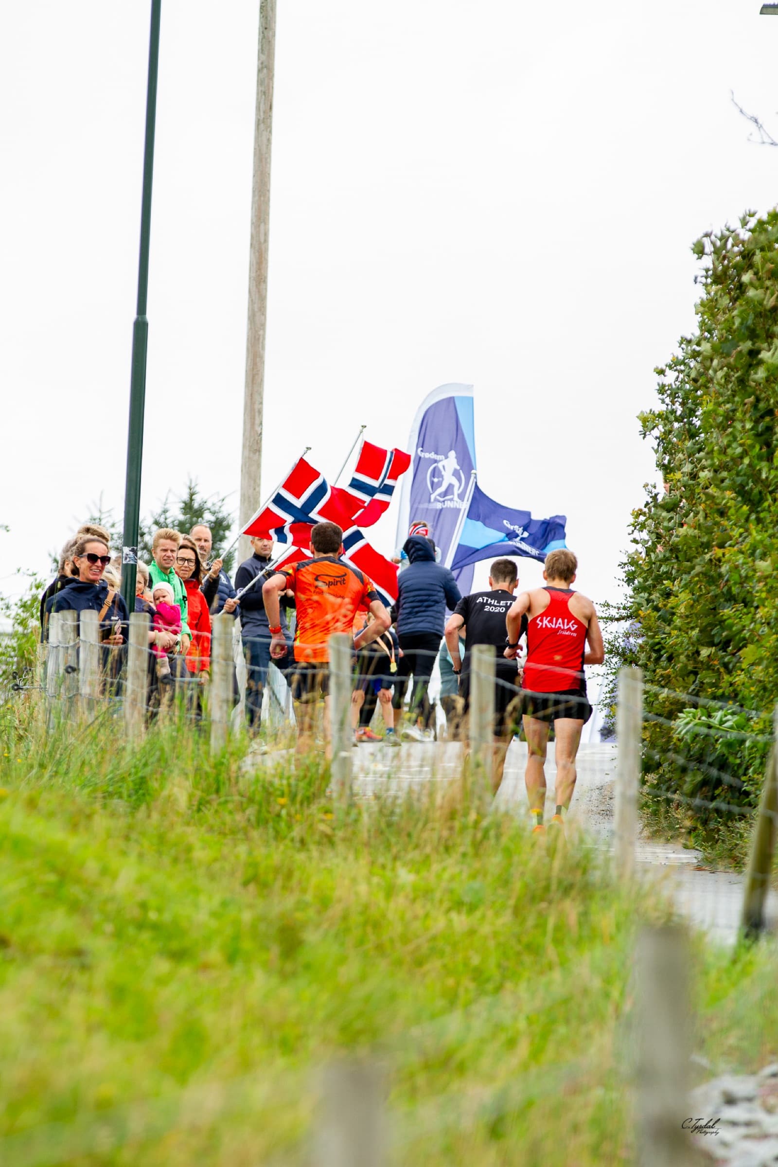 Løpere møter flagg og publikum i bakken under Lavterskel-løpet 2025